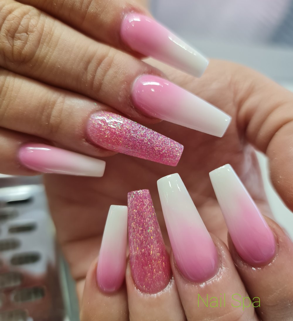 person spreading glittered nail polish on pink nails