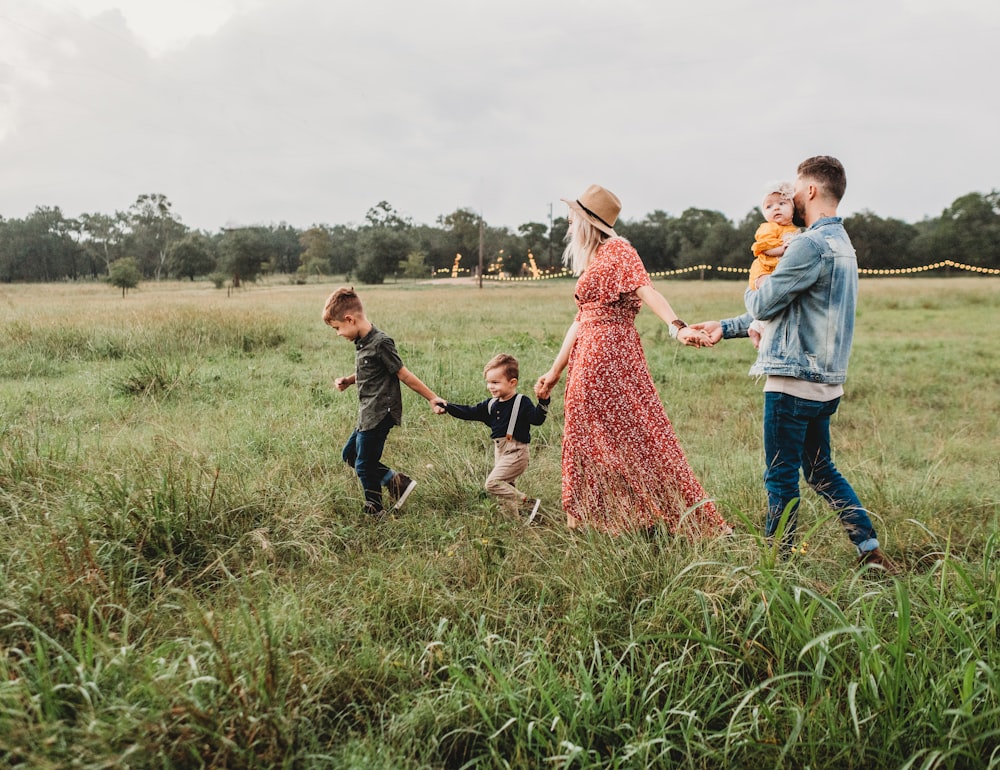 Couple with young children in a meadow enjoying life together after planning their futures.