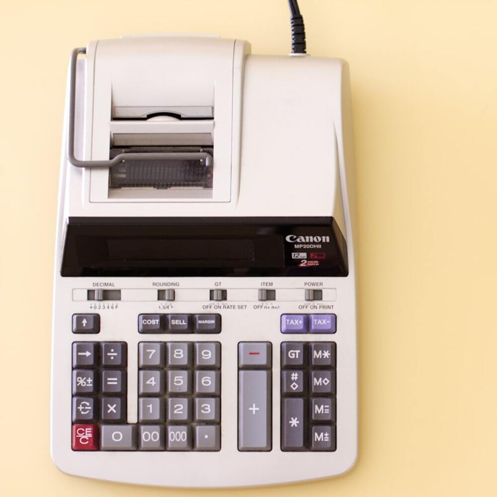Ten key accounting calculator on yellow desk.