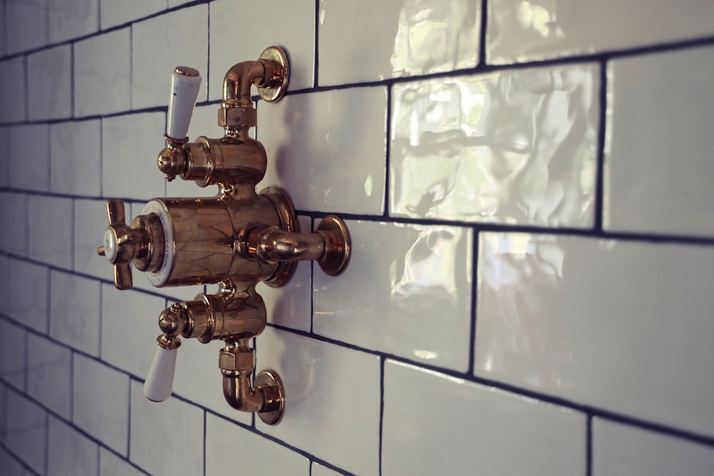Classic brass shower valve on a tiled wall in a victorian style bathroom.