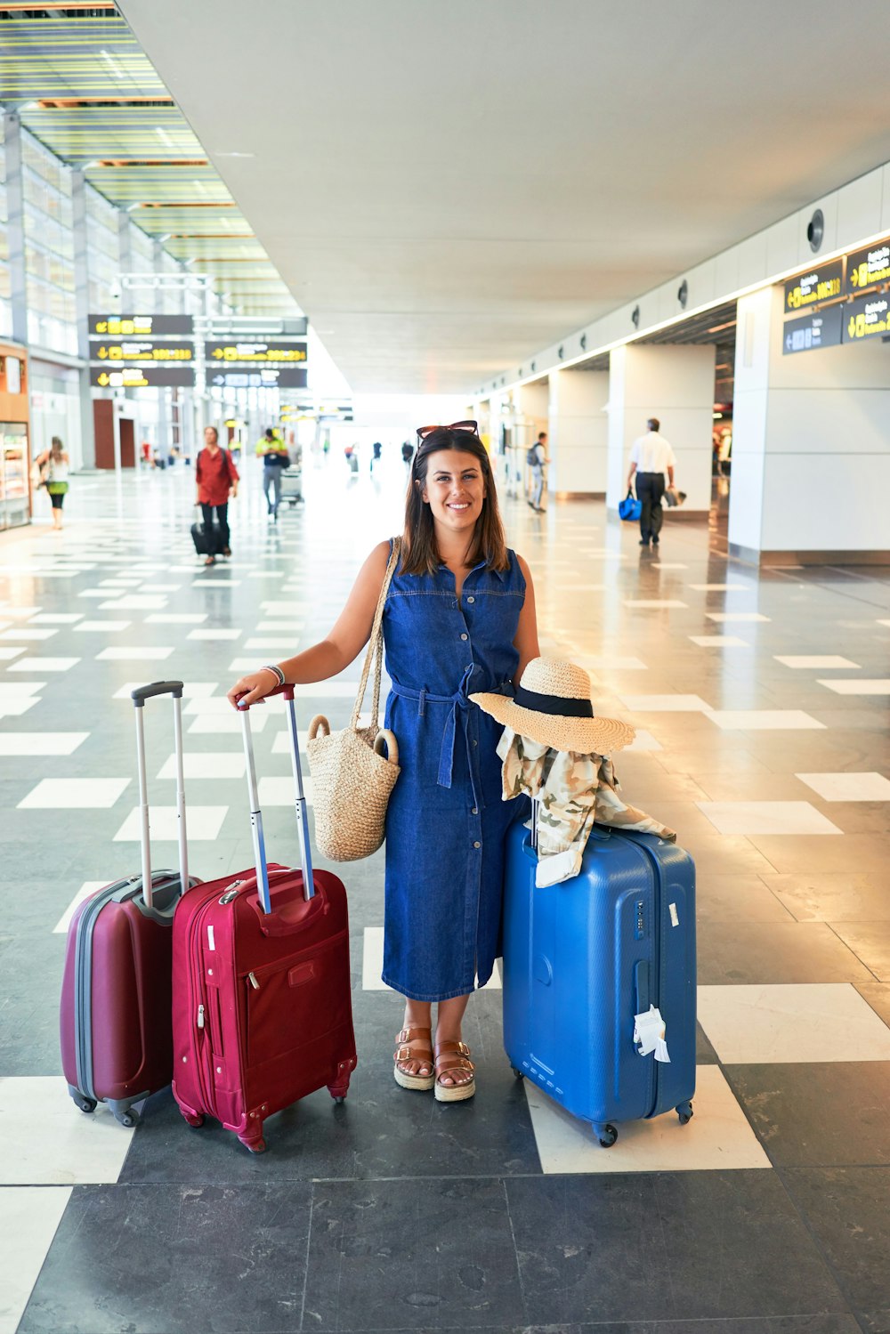 Young beautiful woman at the airport standing with suitcases ready for a vacation trip