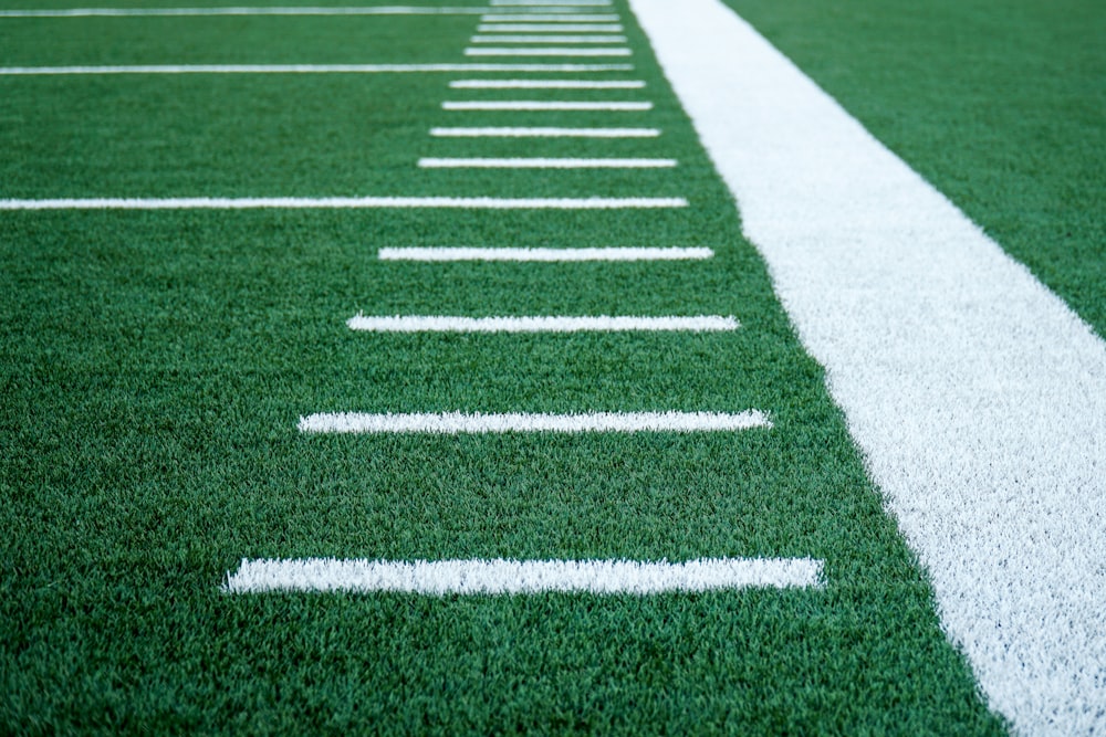 White hashmark lines down the sideline of a green football field.