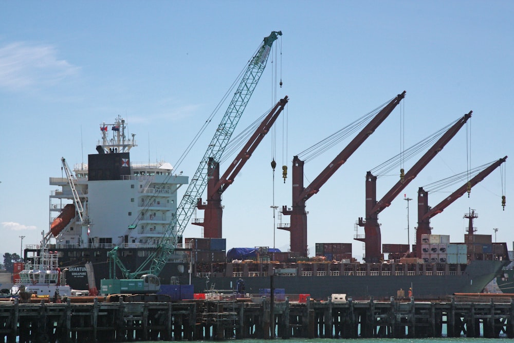 Cranes lined up at port are busy loading and unloading ship's cargo.