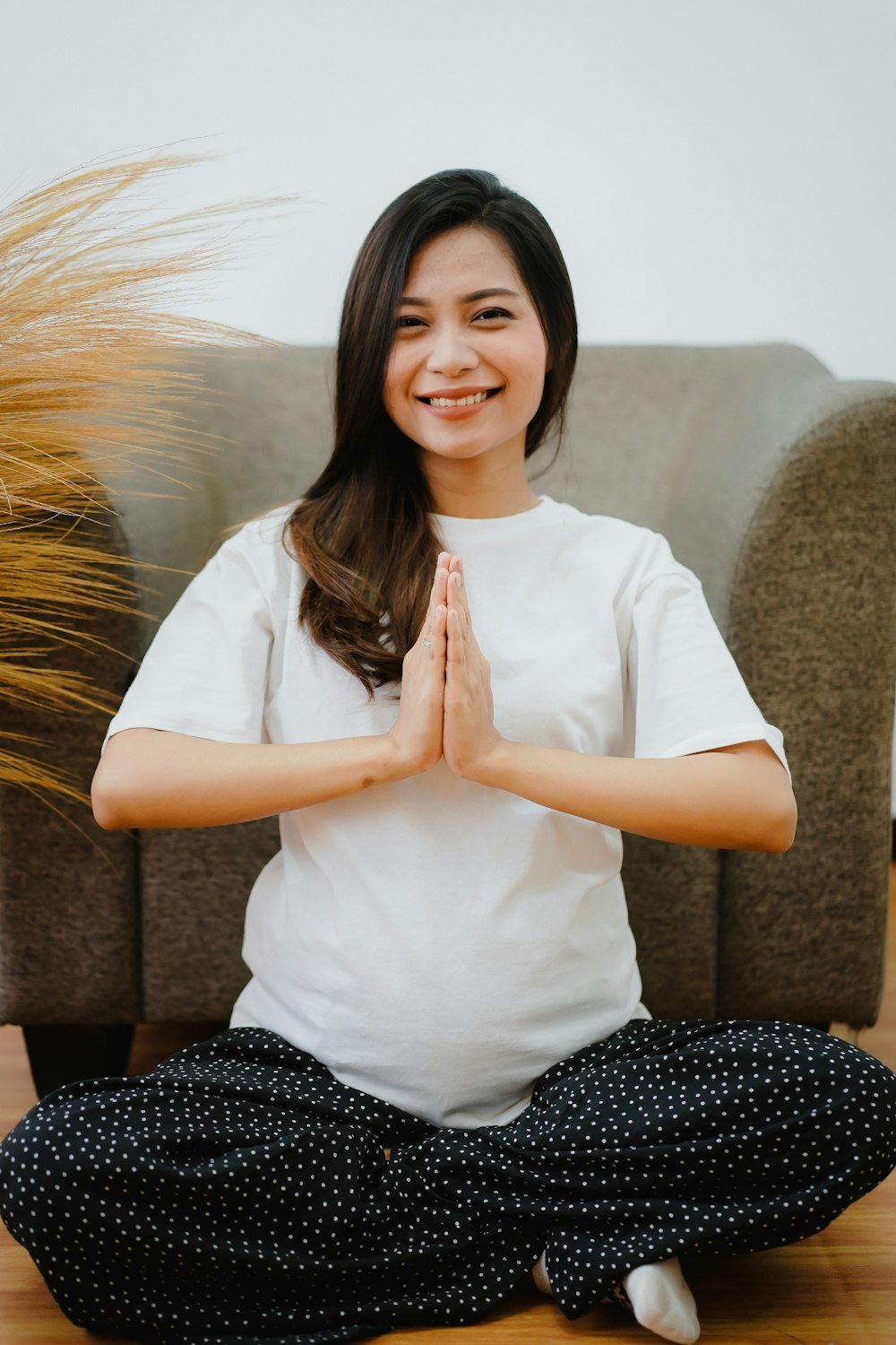Young happy pregnant woman sitting, mediating and relaxing.