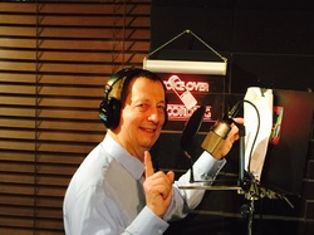 Voiceover specialist and narrator Glen Schultz speaks into his elite studio microphone for his next voiceover project