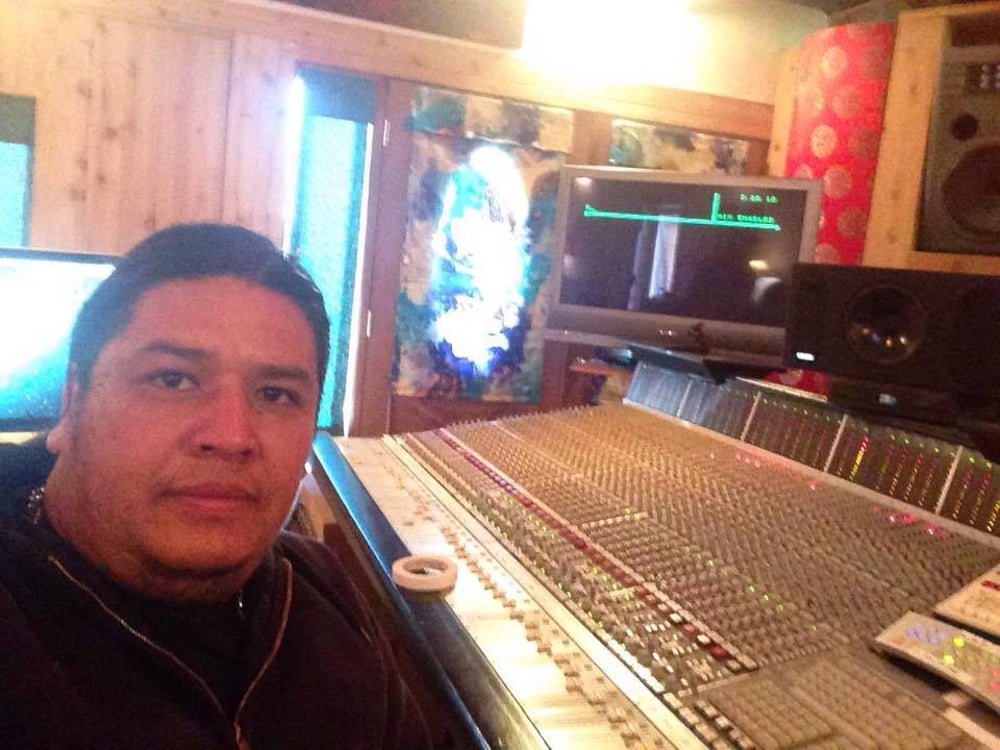 man in front of studio mixer and receiver