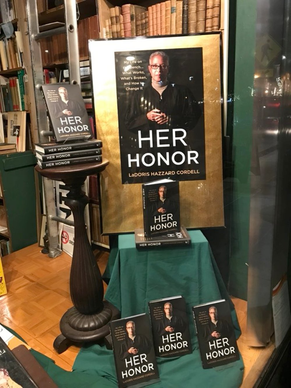Window display of Her Honor at Bell's Books.